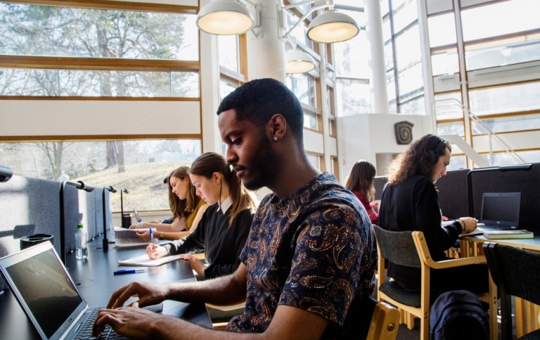 Studenter som pluggar i biblioteket.